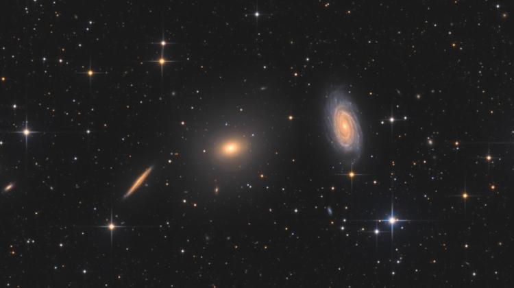 Na zdjęciu widać galaktykę eliptyczną NGC 5982 (w centrum) oraz galaktykę spiralną NGC 5985 (po prawej). Okazuje się, ze te dwa rodzaje galaktyk zachowują się inaczej w przypadku nadmiarowej grawitacji w swoich zewnętrznych rejonach. Źródło: Bart Delsaert (www.delsaert.com).